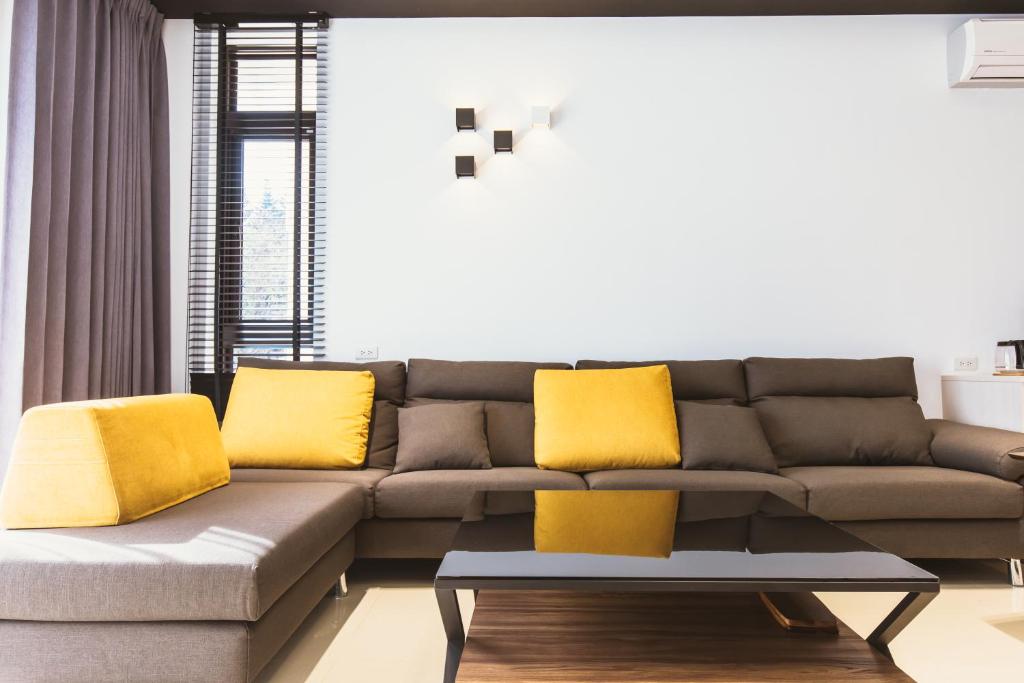 a living room with a couch with yellow pillows at Coolbreeze homestay in Huxi