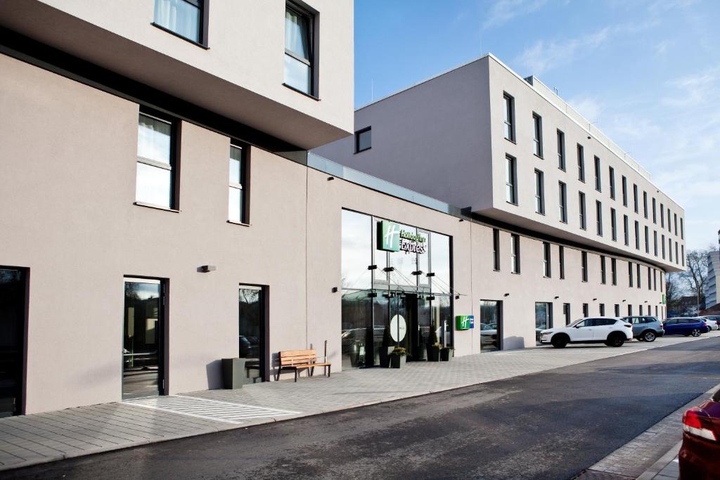 un bâtiment dans une rue avec un banc sur le trottoir dans l'établissement Holiday Inn Express - Trier, an IHG Hotel, à Trèves