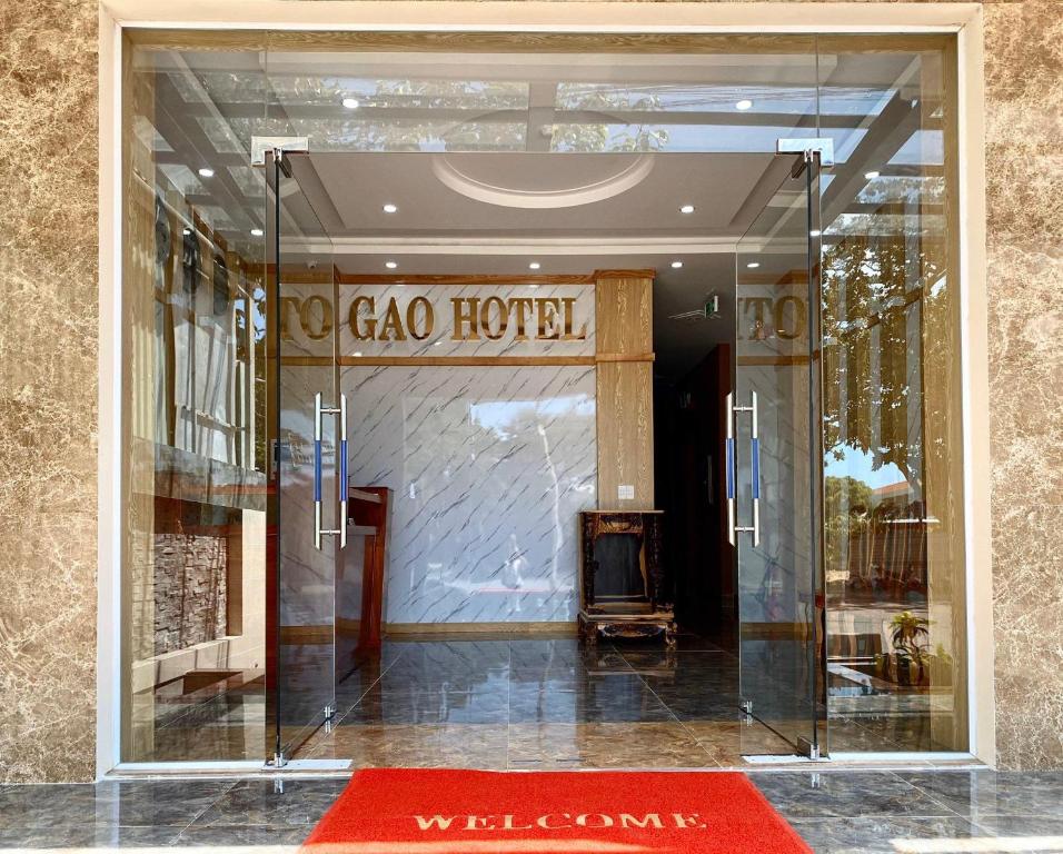 a glass doorway to a hotel with a red rug at Gao Hotel in Con Dao