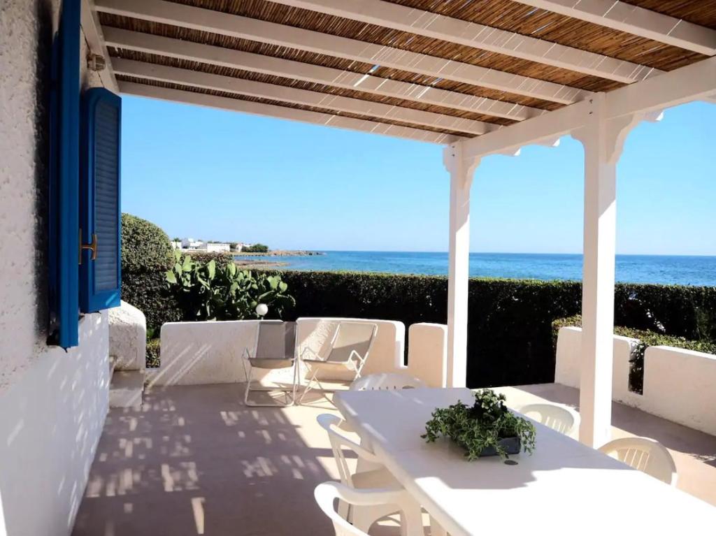 トッレ・スーダにあるVilla Oltremareの海を望むパティオ(白いテーブル、椅子付)