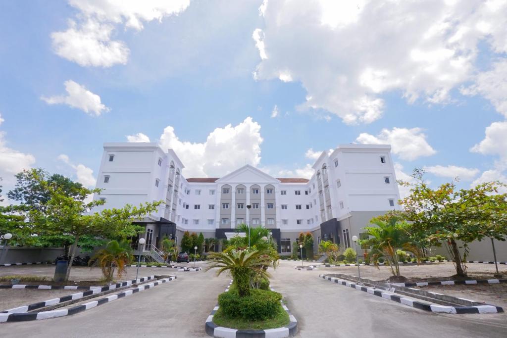 a large white building with trees in front of it at BRITS HOTEL PANGKALAN BUN in Pangkalan Bun