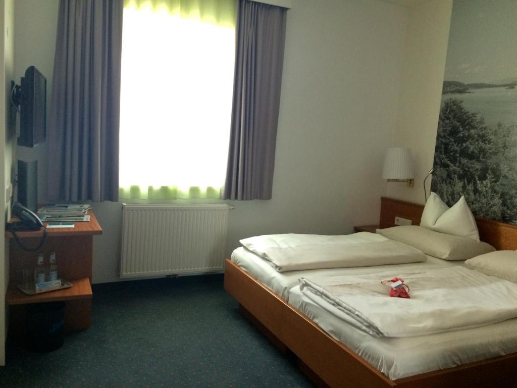 A bed or beds in a room at Seehotel Engstler