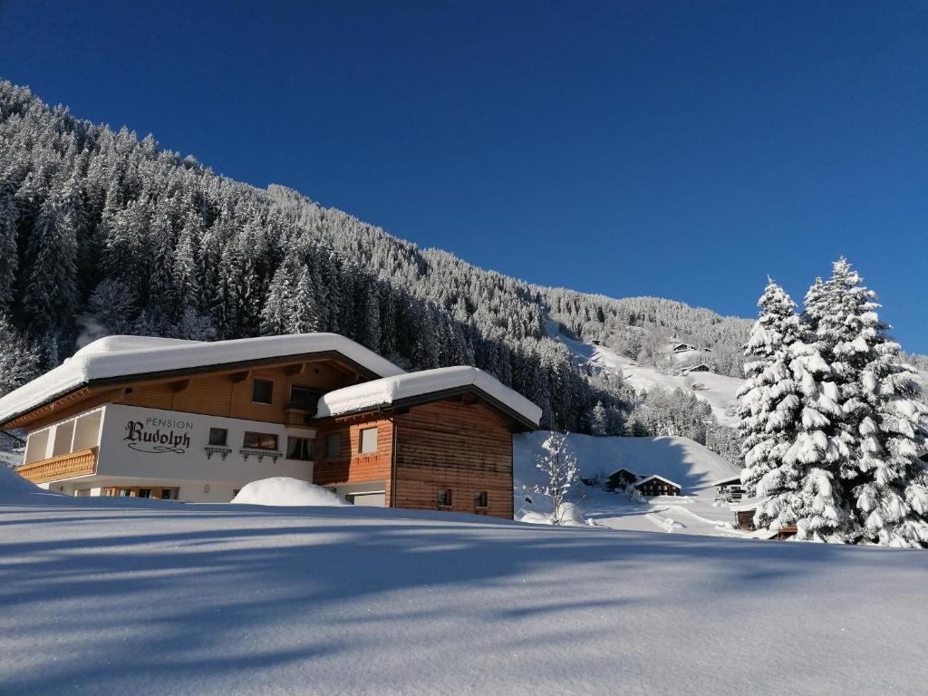 un edificio en la nieve con árboles nevados en Pension Rudolph, en Gaschurn