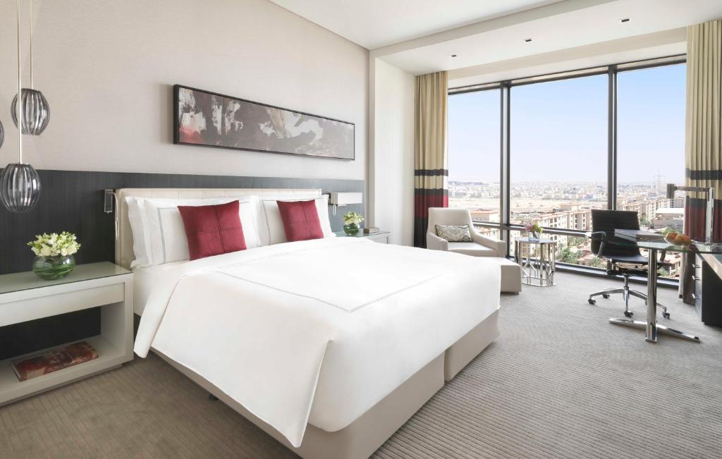 a bedroom with a large white bed and a desk at Fairmont Riyadh in Riyadh