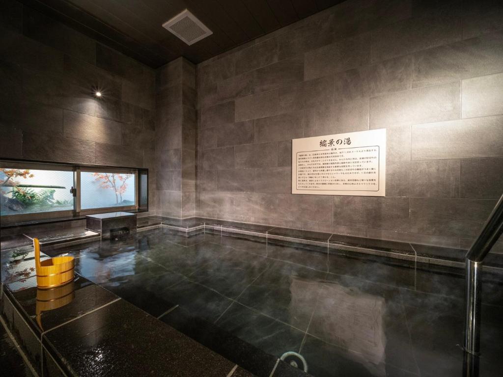 a room with a table and a sign on the wall at Super Hotel Hiroshima Yagenboridori in Hiroshima