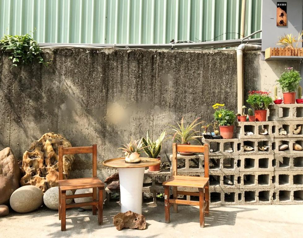 Ting-liao的住宿－蒔光漫築民宿，庭院配有两把椅子和一张桌子,还有一些植物