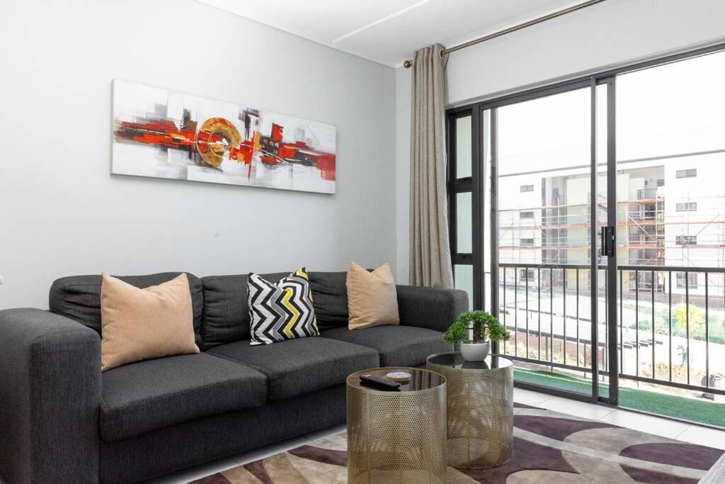 a living room with a couch and a large window at Alimama Spaces: The Robert's Greenlee Apartment in Sandown