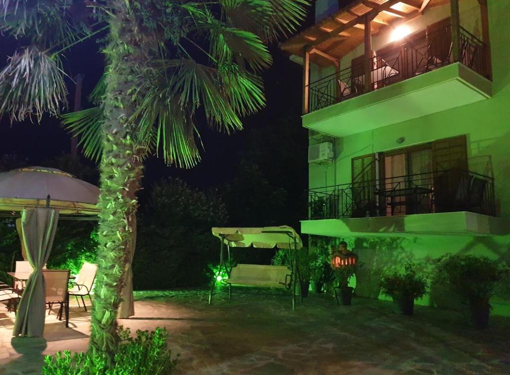 a building with a palm tree in front of it at night at ANTONY's LUXURY APARTMENTS in Nikiti
