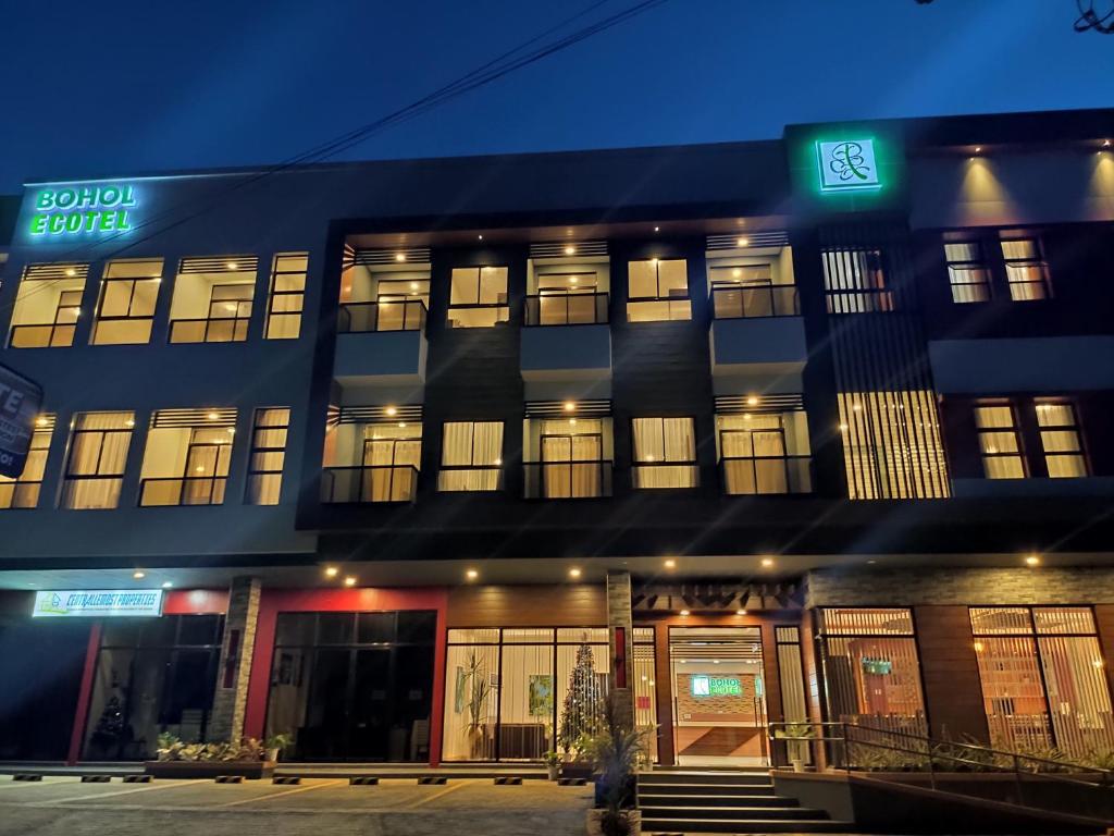 un edificio azul con ventanas iluminadas por la noche en Bohol Ecotel en Tagbilaran City