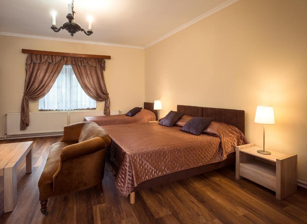 1 dormitorio con 1 cama, 1 silla y 1 ventana en Honti Apartmanház en Visegrád