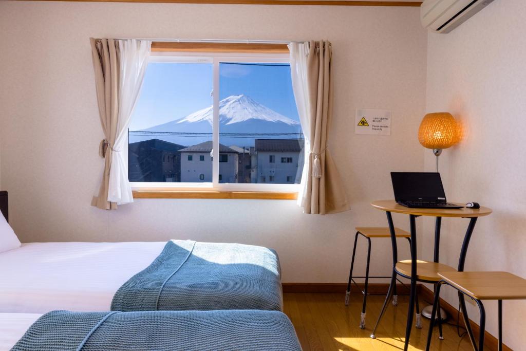 a bedroom with a window with a view of a mountain at Ma Maison Mt. Fuji Kawaguchiko in Fujikawaguchiko