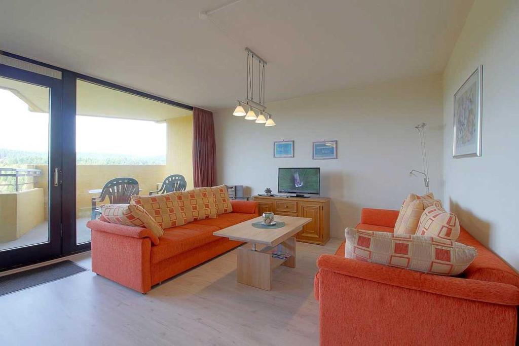 a living room with two orange couches and a table at Apartment 480 in Hohegeiß