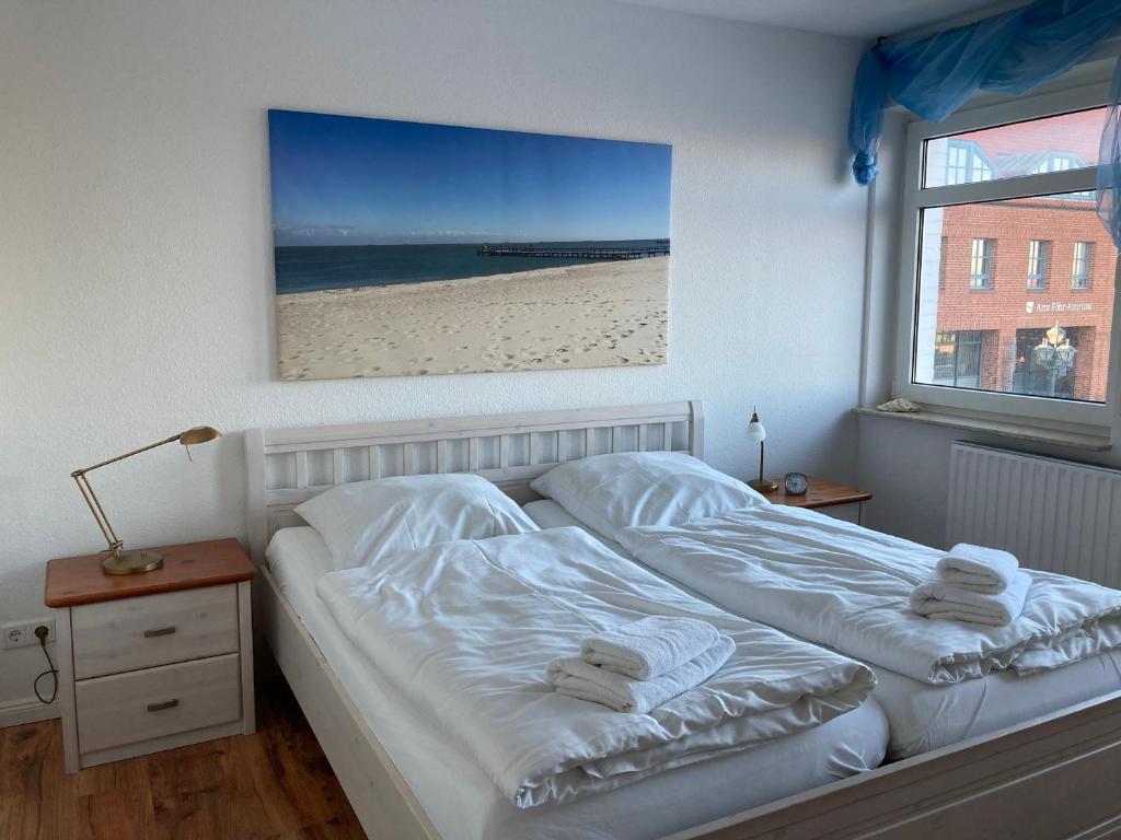 1 dormitorio con 1 cama con una foto de playa en Hellinghaus FeWo 1 Wellenreiter, en Wyk auf Föhr