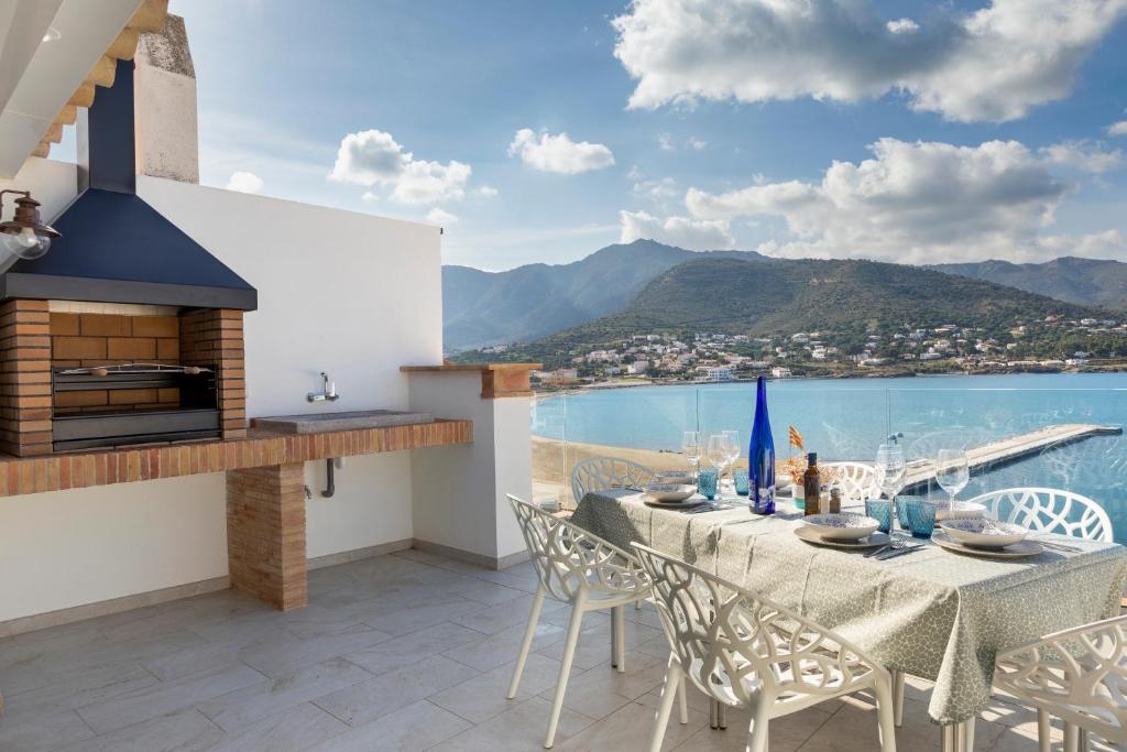 een tafel en stoelen op een balkon met uitzicht op het water bij Playa Vista Mar Duplex in Port de la Selva