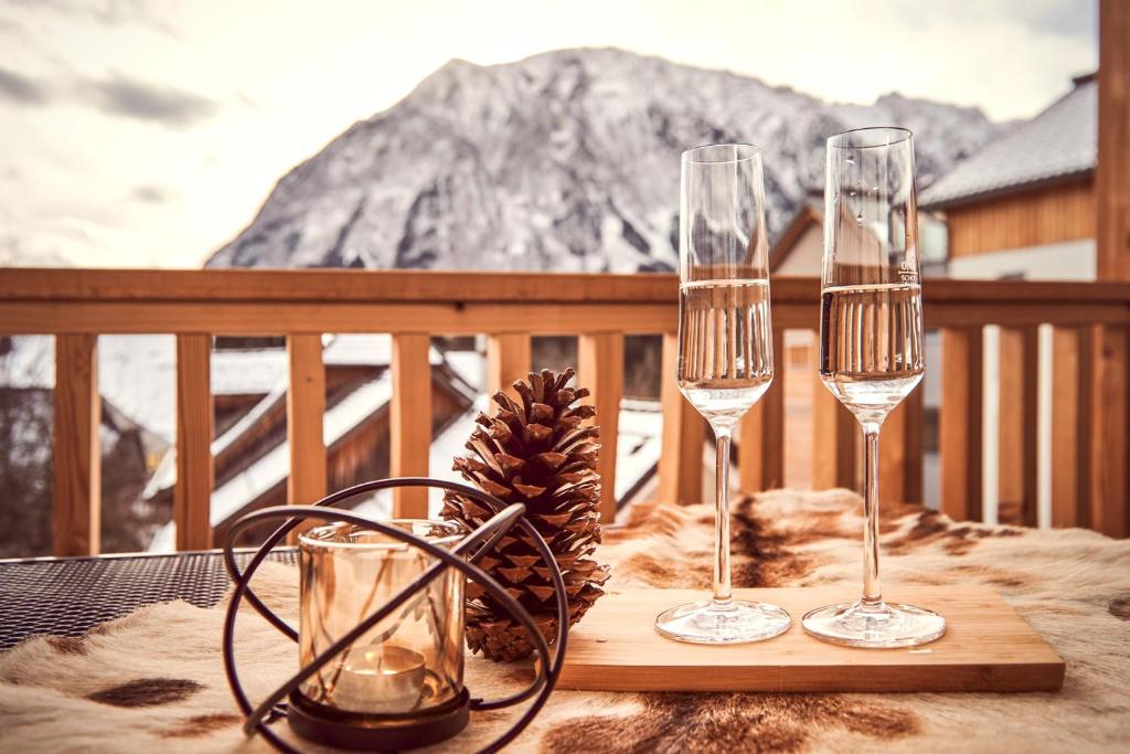 a table with two wine glasses and a pine cone at die Tauplitz Lodges - Alm Lodge A6 by AA Holiday Homes in Tauplitz