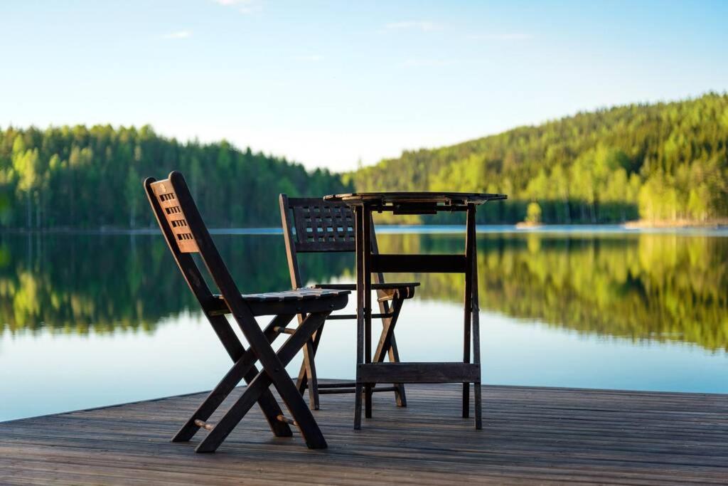 une table et deux chaises assises sur un quai dans l'établissement Vuorijärvi cottage, à Enonkoski