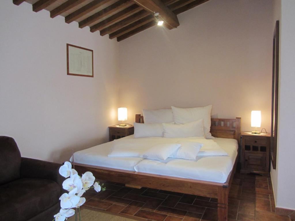 a bedroom with a bed with white sheets and pillows at Tenuta Seripa in Sassetta