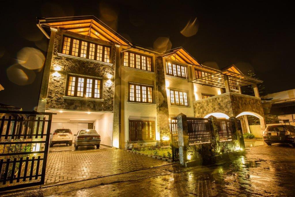 a large house with a car parked in front of it at Seasons Villa - Nuwara Eliya in Nuwara Eliya