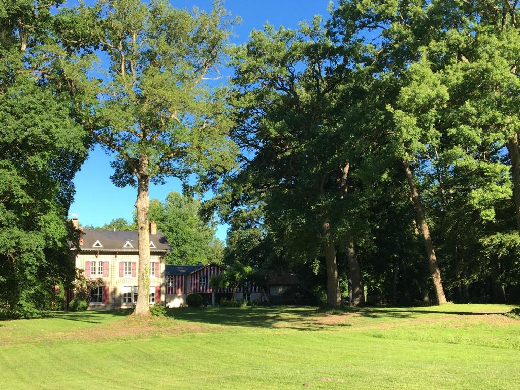 a house in the middle of a field with trees at Le Vivier in Trigny