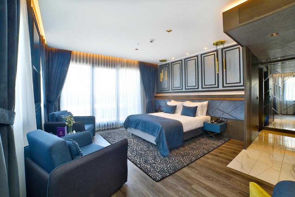 a bedroom with a bed and a couch and a chair at Amethyst Hotel in Istanbul