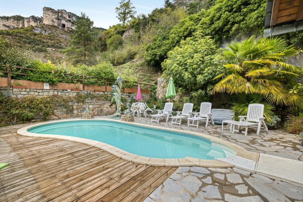 einen Pool mit Stühlen und eine Terrasse mit einem Hügel in der Unterkunft Villa de 4 chambres avec vue sur le lac piscine privee et jardin amenage a Saint Pierre des Tripiers in Saint-Pierre-des-Tripiers