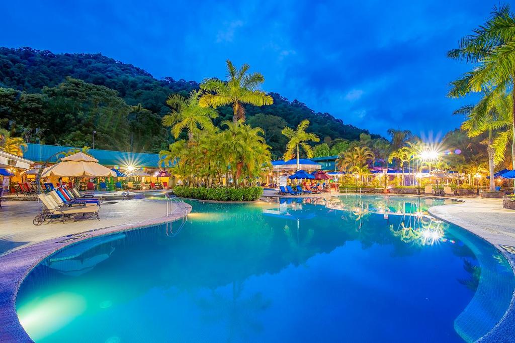 a swimming pool at a resort at night at Hotel Casa Roland Golfito Resort in Golfito