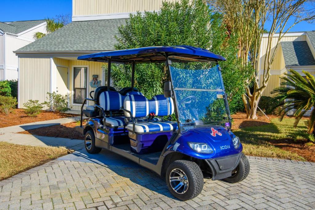 un carrito de golf con asientos azules aparcado en la entrada en Sandpiper Village 715 en Destin