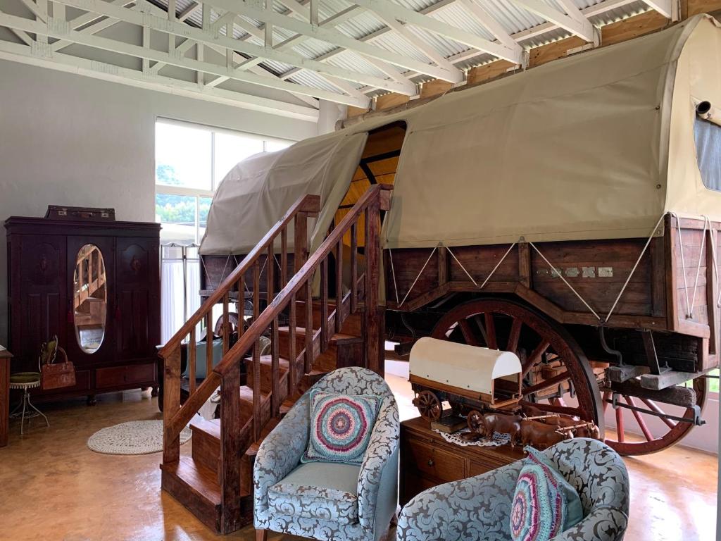 Jelani Guest House في وايت ريفر: عربة قديمة في غرفة مع كراسي