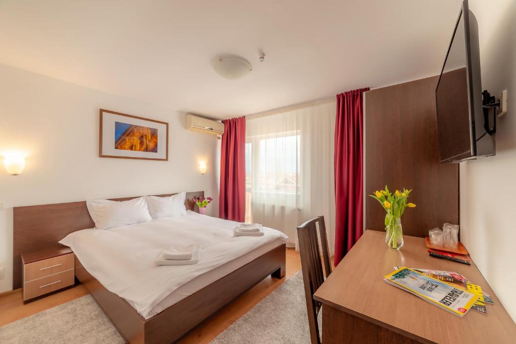 1 dormitorio con 1 cama y escritorio con ordenador en Pension Cluj, en Cluj-Napoca