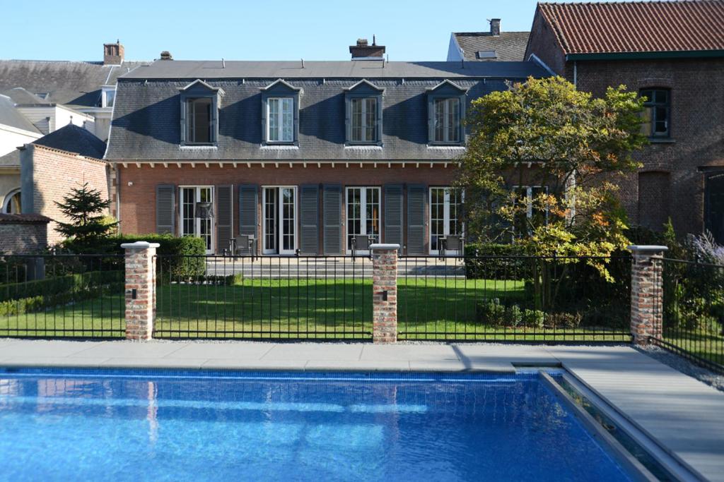 una casa con piscina frente a una casa en Notarishuis Beveren B&B, en Beveren