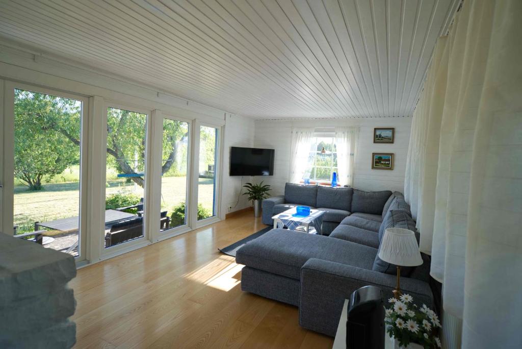 ein Wohnzimmer mit einem Sofa und einem TV in der Unterkunft Rosenborgs Friluftspensionats stugor med kök in Färjestaden