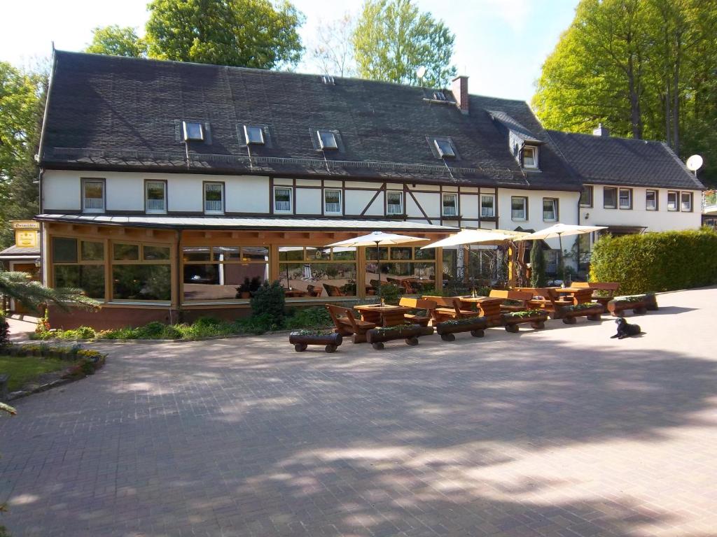 a large building with tables and benches in front of it at Gaststätte & Pension Oelmuehle in Oberschöna