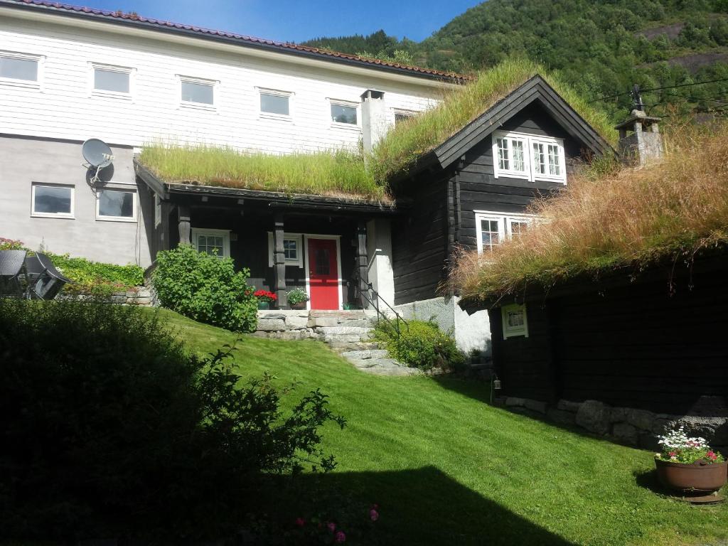 una casa con techo de hierba y puerta roja en Flotunet - Anestova, en Stryn