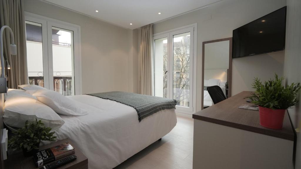 1 dormitorio con 1 cama y escritorio con TV en Hotel Ciudadela Pamplona, en Pamplona
