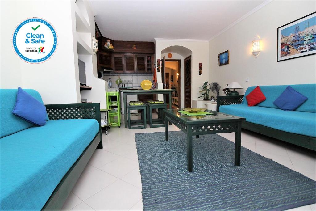 アルブフェイラにあるBellavista Center - Albufeiraのリビングルーム(青いソファ、テーブル付)