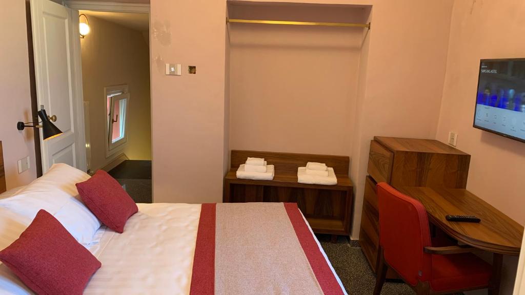 a hotel room with a bed and a desk and a television at Dimora del Leone Gaeta in Gaeta
