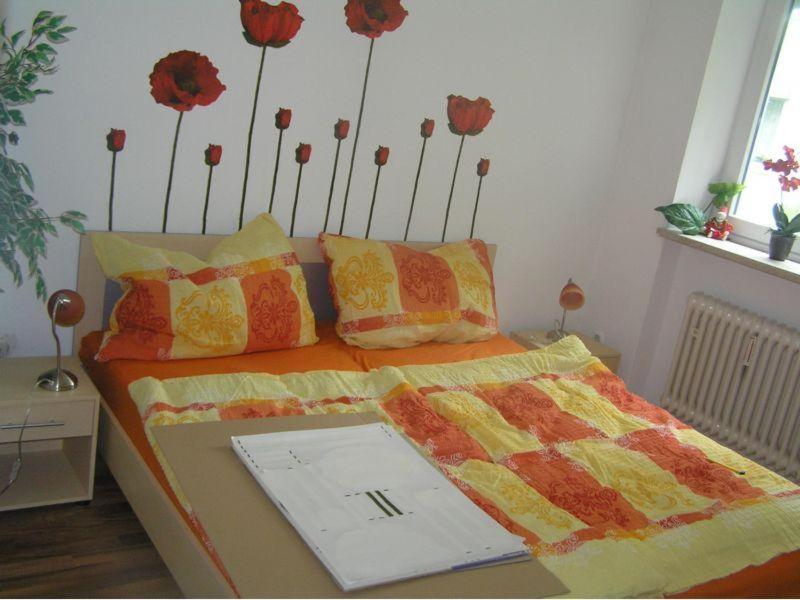 a bedroom with a bed with flowers on the wall at Fewo Andrea in Bad Reichenhall