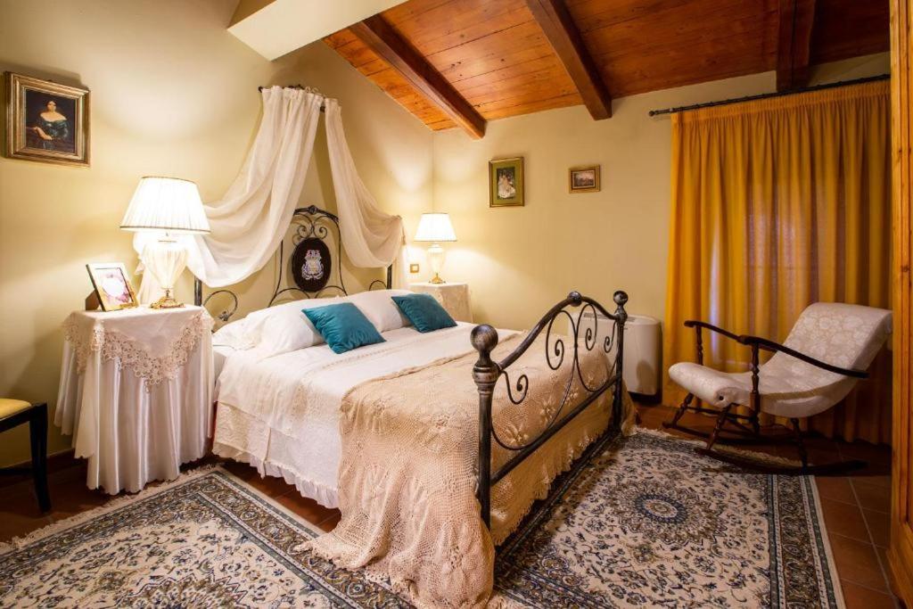 a bedroom with a bed and a chair at Dimora di Charme Villa Sant'Erasmo in Fumone