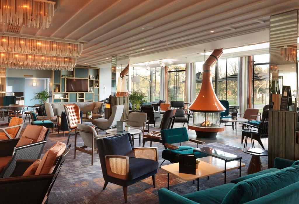 a living room filled with furniture and tables at The Runnymede on Thames in Egham
