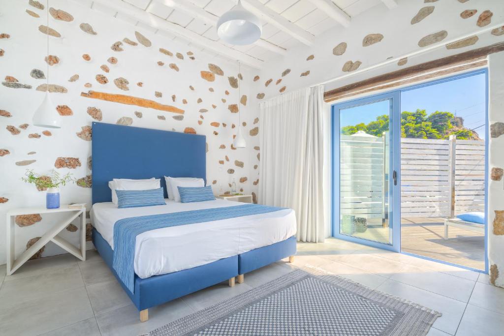 Veranta Luxury Suite في خورا سفاكيون: غرفة نوم بسرير أزرق ونافذة كبيرة