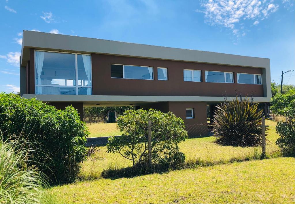 a large house on a field with bushes at Casa del Mar in Mar del Plata