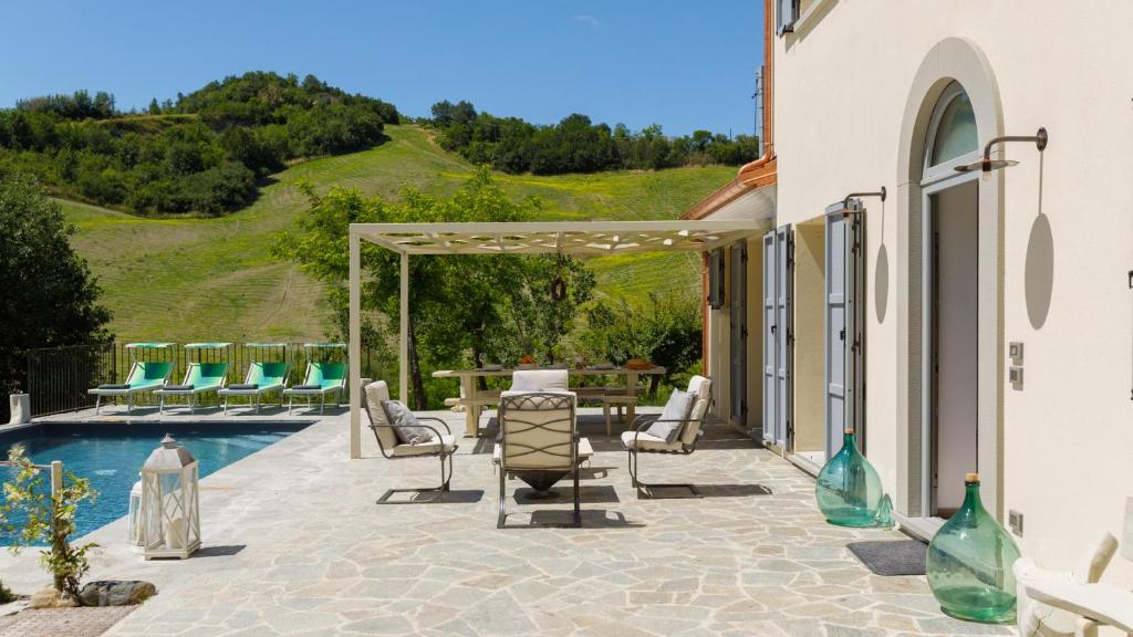 d'une terrasse avec des chaises et une table à côté de la piscine. dans l'établissement Villa Mia 6, Emma Villas, à Mercato Saraceno