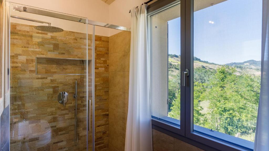 La salle de bains est pourvue d'une douche et d'une grande fenêtre. dans l'établissement Villa Mia 6, Emma Villas, à Mercato Saraceno