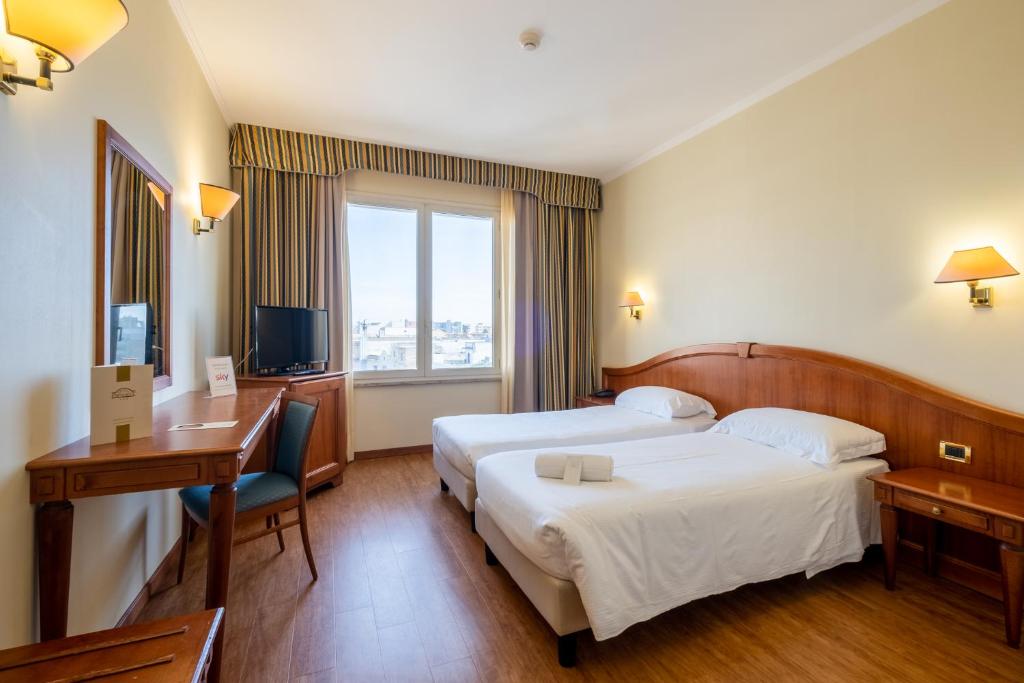 Postel nebo postele na pokoji v ubytování Hotel President