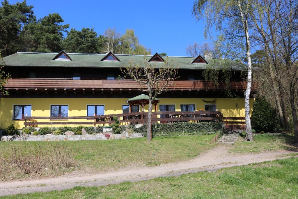a large yellow house with a green roof at Hotel und Restaurant Karpfenschänke in Schenkendöbern