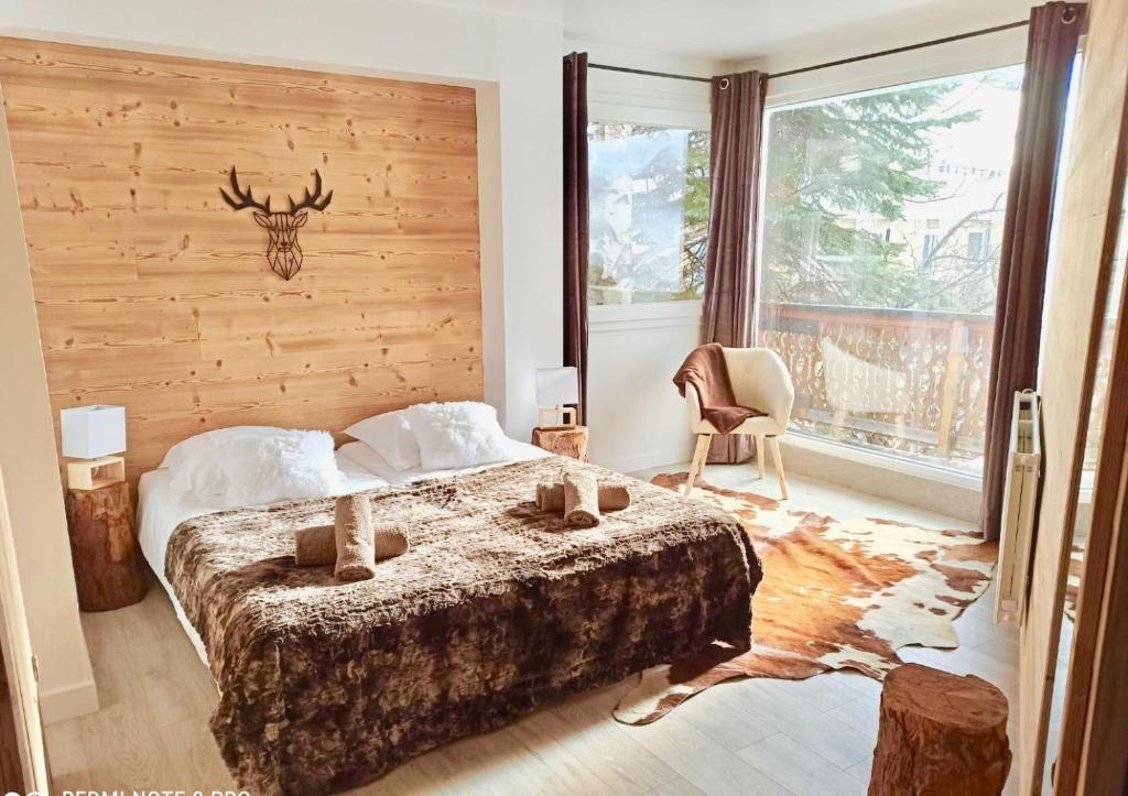 a bedroom with a bed with a deer head on the wall at Appartement spacieux 300m2 - Sauna - BBQ - Terrasse in Les Deux Alpes