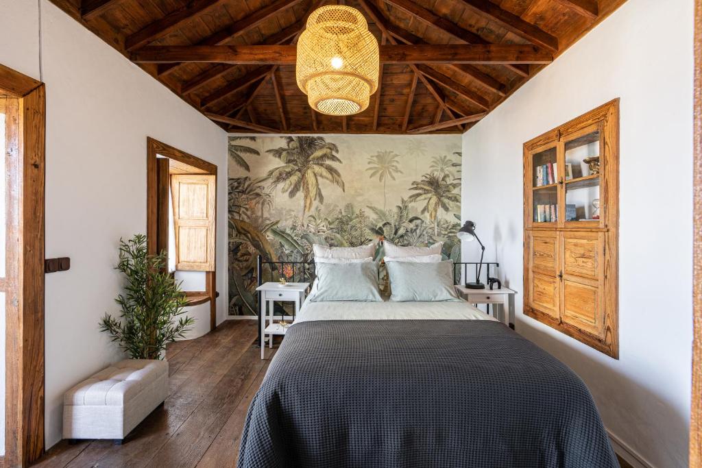 een slaapkamer met een groot bed en een schilderij aan de muur bij La Carmona House in Lodero