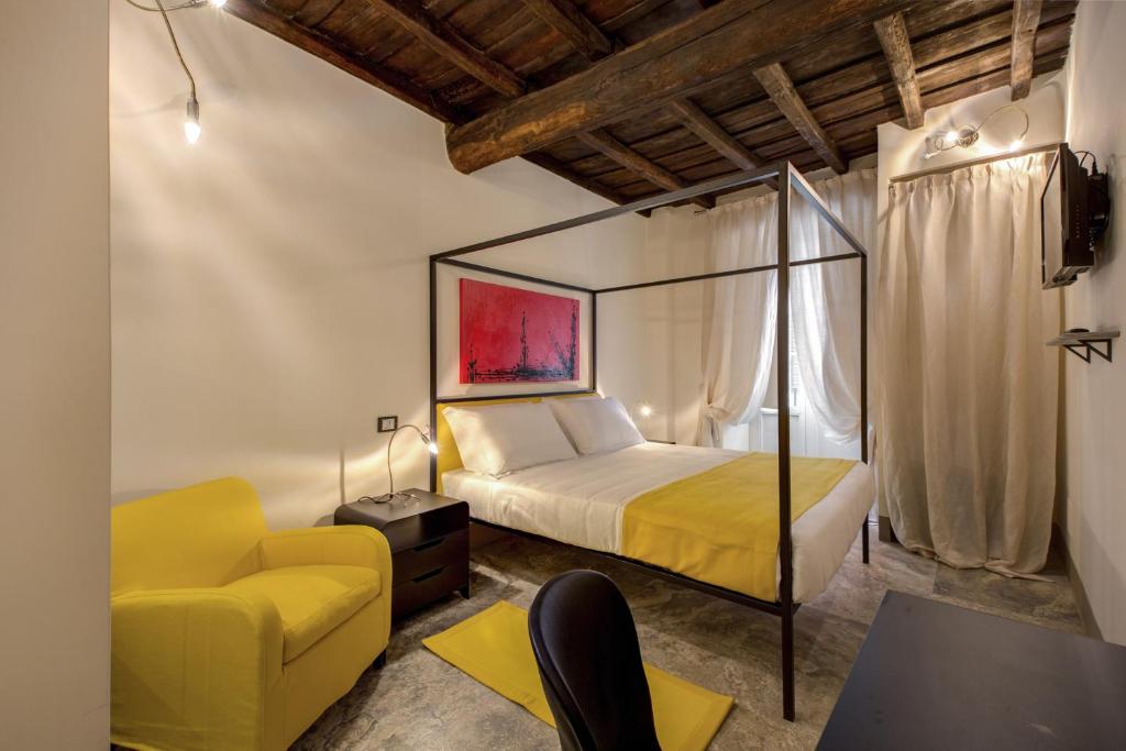 1 dormitorio con 1 cama y 1 silla amarilla en Residenze Argileto, en Roma