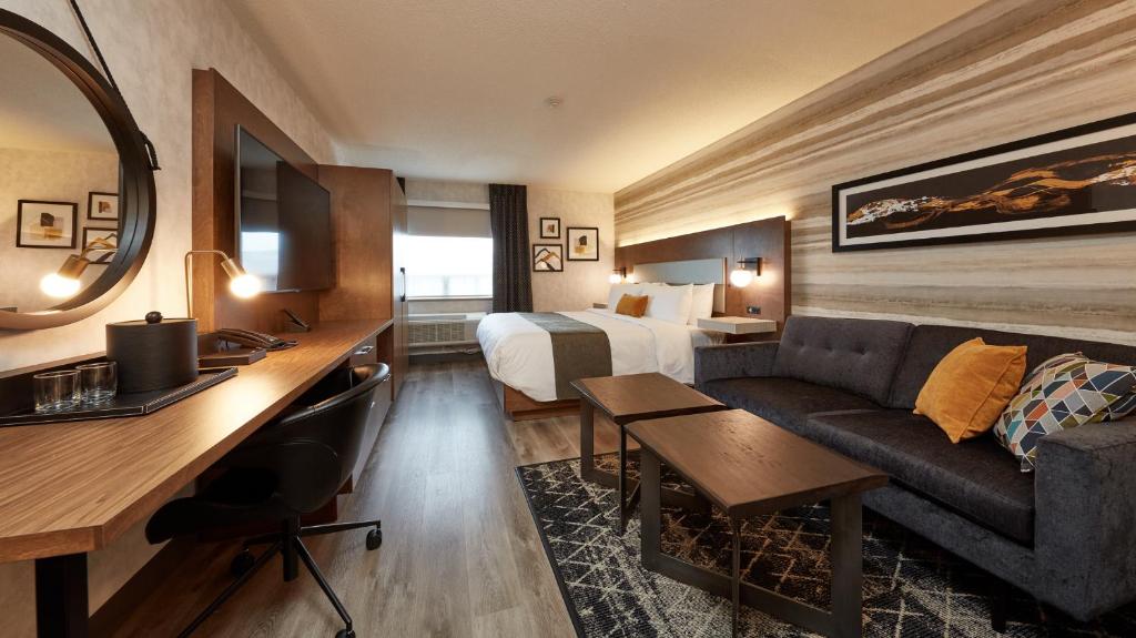 Stay Inn Hotel Toronto في تورونتو: غرفة في الفندق بها سرير وأريكة ومكتب