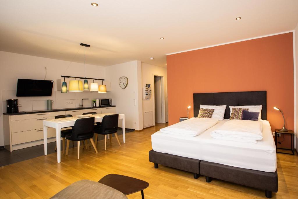 1 dormitorio con cama, escritorio y cocina en Ferienwohnung Höchsten, en Friedrichshafen